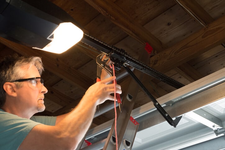 Professional automatic garage door opener repair service technician working closeup