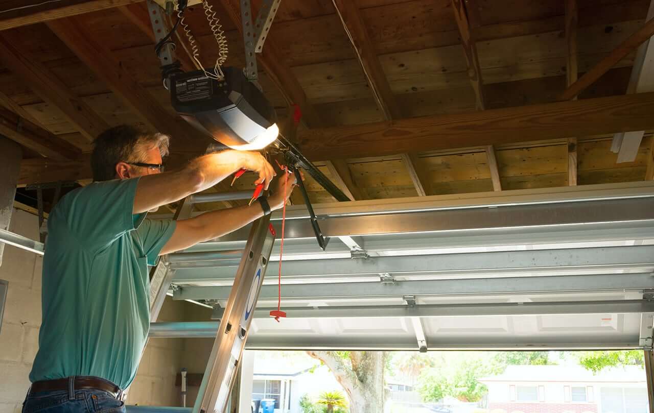 homeowner repairing garage door opener spring cable