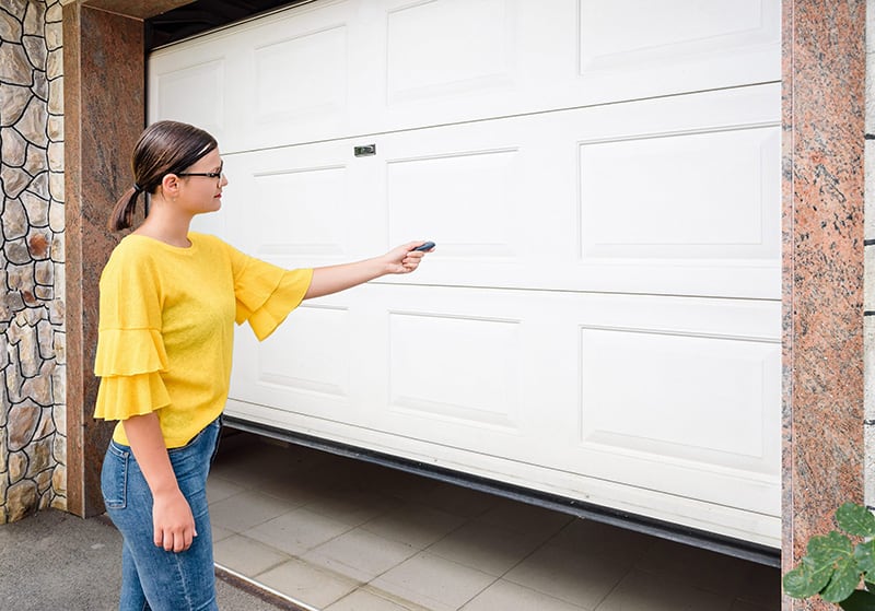 woman opening garage door with remote