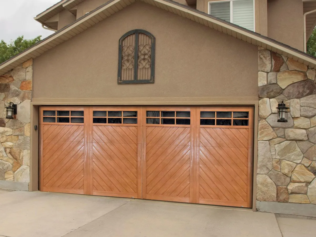 Modern chalet style faux wood garage door with chevron design made from composite wood over steel material.